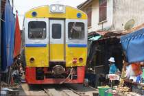 Strecken-KM 33,600, gleich beim Bf. Mae Klong am 27.März 2010. Der nummernlose Triebwagen auf der Fahrt über die nun frei gegebene Strecke, welche als Markt genutzt wird.