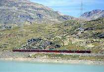 RhB Schnellzug HEIDI-EXPRESS 503 von Landquart �ber Davos nach Tirano am 26.08.2000 am Lago Bianco zwischen Ospizio Bernina und Alp Gr�m mit Triebwagen ABe 4/4III 54 - ABe 4/4II 43 - As 1291ff - Bs 2502ff - BD 2475 - B - B - B. Hinweis: Teleaufnahme, Zugentfernung 600m!  
