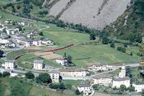 RhB Schnellzug BERNINA-EXPRESS D 500 von Tirano nach Chur am 29.08.1993 oberhalb Brusio nach der ersten Kehre mit den Triebwagen ABe 4/4II 44 - ABe 4/4II 45 - B 2493 - B 2492 - A 1273 - A 1274 - BD 2475 - B 2497 - B 2796. Hinweis: EW-IV-Kompo mit 7 Wagen, Vollast. Rechts unten bei der Kirche ist das Bahnhofsgel�nde.
