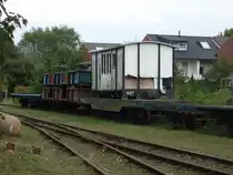 Der wei�e Wagen entstand Ende 1983 aus dem gedeckten G�terwagen 046 und dem Hilfsgep�ckwagen 164, der seit 1994 die Nr. 048´´ tr�gt. Bei dem Umbau wurden die Holzw�nde durch Blech ersetzt und eine vierteilige Faltt�r eingebaut. Er war der letzte verbliebene gedeckte G�terwagen auf Wangerooge.
Dieses Abstellgleis ist von der Stra�e frei zug�nglich! Aufgenommen am 01.08.2010 auf Wangerooge.