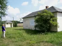 Empfangsbe�ude Oberschar mit Abtritt am 4. 8. 2010. Die gro�e Tafel verk�ndet stolz, da� die Anlage 1993 durch eine Spendeaktion dreier Unternehmen saniert und in einen Jugendclub bzw. Sportanlage umfunktioniert wurde. Ob die Jugendlichen nun ihren Club durch das Geb�sch direkt am Eingang betreten k�nnen...?