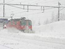 Re 4/4 mit IR 2178 bei Durchfahrt im tief verschneiten Bahnhof Airolo, 07.02.2010.
