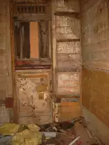 Hier sieht man die Innenansicht vom zweiten s�chsichen Wagenkasten in Schlettau.Oberhalb der T�r sind die L�ftungsschlitze zu sehen.Bei den sp�ter gebauten Wagen entfiehl die L�ftung oberhalb der T�ren,da diese sich dann im Oberlichtaufbau befand.Unterhalb des Fensters ist noch die Br�stungsleiste in mahagoni.Im unteren Bereich der T�r ist eine Rahmung zu erkennen,was darauf schliesen l��t,dass dieser Wagen von innen mal mit Stoff bespannt war. Somit entstammte er der 2ten Klasse.Aufnahme 26.07.2010  