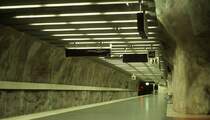 Tunelbana Stockholm. Die Station  Mörby Centrum  (1975) - 

... ist eine typische in den Fels gehauene Station. Die Felswände wurden lediglich mit einer dünnen Schicht Spritzbeton überzogen und dann künstlerisch gestaltet. Es gibt 28 Stationen solcher Bauart, neuere bestehen aus eine Bahnsteighalle, während die älteren aus zwei durch Querschläge mit einander verbundenen Bahnsteigtunnelröhren bestehen. Die U-Bahn Stockholm gehört damit wohl zu den schönsten Metros weltweit. 

Scan vom Dia, 1990 (M)