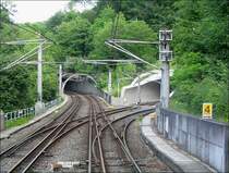 . Faszination Stadtbahn Stuttgart - 

Blick aus der fahrenden Bahn auf den Abzweig der U8 in Richtung  Waldau  nach rechts. Geradeaus geht es hinunter in den Talkessel. Die Meterspur führt nur geradeaus. Nach dem im Bild zu sehenden Kurztunnel folgt ein langer gebogener Tunnel tief im Berg mit 70 Promille Gefälle. Wir befinden uns hier unterhalb der Station  Weinsteige . 

2004 (J)