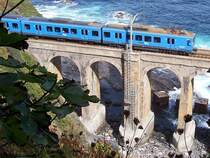 Triebzug Baureihe 3500/6500 am 29.09.2005 zwischen Bermeo und Mundaka, die Kl�tze hinter der Br�cke sind Wellenbrecher. Die Aufnahme wurde von einen ca. 50 cm breiten Streifen gemacht, dann ging's fast senkrecht abw�rts, doppelte H�he wie die Br�cke, einziger Standpunkt mit eingeschr�nkter Sicht auf die Br�cke. Zugang zum Fu� der Br�cke nur �ber die Leiter am Pfeiler, sonst nur glatte Felsw�nde.