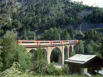 MGB exFO 1.Klasse-PANORAMA-GLACIE-EXPRESS B 902 von Zermatt nach St.Moritz am 24.05.1997 auf Grengiols-Viadukt mit E-Lok HGe 4/4II 107 - RhB WR 3811 - AS 4023 - BVZ AS 2011- AS 4027 - AS 4022. Hinweis: Oben ist die Streckenf�hrung nach dem Kehrtunnel zu sehen!
