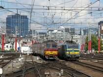 Vor der Kulisse der Br�sseler City kreuzen sich im Vorfeld von Bruxelles-Midi die einfahrende 2131 mit ihren M4-Wagen und der ausfahrende Triebwagen 820 der Serie AM75. Diese Triebwagen bestehen aus 4 Elementen mit 358 Pl�tzen (gegen�ber 2 bei den �lteren Serien), um dem damals immer gr�sser werdenden Verkehrsaufkommen gerecht zu werden. Aufgenommen am 17/09/2010 vom Bahnsteig 10.