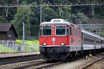 Interregio mit der Re 4/4 II 11122 passiert den Bahnhof Amsteg-Silenen Richtung Fl�elen.