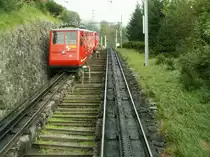 Blick aus dem bergw�rts fahrenden Zug.Zwei auf die Einfahrt wartende Wagen bei der Talstation in Alpnachstad.Im Juni 1889 wurde die Bahn er�ffnet(Dampfbetrieb)1937 wurde die Strecke elektrifiziert.Eine Dampflok mit Vorstellwagen ist noch im VHS Luzern zu sehen,eine weitere,im Deutschen Museum M�nchen.Alpnachstad 07.10.10