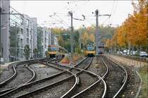 . Wendeanlage und Durchgangstrecke -

Vogelsang: Eine U4 aus Botnang kommt den Berg herunter, während eine U9 in ihrer Wendeanlage auf die Rückfahrt nach Hedelfingen warter. Im Hintergrund kann man auf der anderen Seite des Kurztunnels ein U4 in Richtung Botnang in der Station  Herderplatz  erkennen. Anstelle der heutigen Wohnbebauung links stand ein Straßenbahndepot. Die Straßenbahn selbst ging auf der Straße rechts in kurvenreicher Strecke über den Sattel. 

21.10.2005 (M)