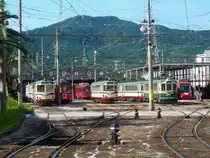 Grunddaten der Strassenbahn K�chi: Diese relativ abgelegene Stadt auf der kleineren Insel Shikoku und dazu noch jenseits sehr hoher Berge besitzt 3 Strassenbahnlinien, eine nach Westen (11,2 km), eine nach S�den (3,2 km) und eine nach Osten (10,9 km); 1067mm-Spur, 600 V Gleichstrom. Sie wird vor allem von Sch�lern und alten Menschen benutzt und gilt deshalb (noch) als sozial notwendig; Leute im Beruf haben eigene Autos und sch�tzen die Strassenbahn wenig. 21.September 2009. (Aufnahme von einem �ffentlichem Weg aus mit Zoom)