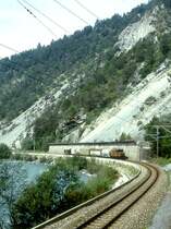 RhB G�TERZUG 5238 von Disentis nach Landquart am 03.09.1997 in der RUINAULTA kurz vor Trin mit E-Lok Ge 6/6I 414 - Uace 7993 - Haikv 5102 - Haiqy 5171 - Uce 8012 - Uce 8072 - Gbkv 5574. Hinweis: Blick auf Wuhrenverbauung und Steinschlagschutzmauer.
