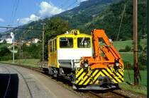 RhB BAUDIENSTZUG 9238 von Tavanasa nach Ilanz am 25.08.1997 in Tavanasa mit Traktor Tm 2/2 81 - Kkl 7070. Blick Richtung Kirche.
