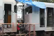 Die �u�eren Aufarbeitung der Triebwagentype กซข. (USKH.) im Bf. Kantang erfolgt unter in unseren Breiten kaum vorstellbaren Umst�nden, und trotzdem sind die Beteiligten gut gelaunt. 25.Oktober 2010.