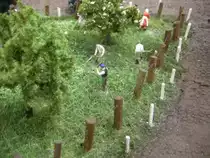 Auf der kleinen Wiese ist die Bauernfamilie bei der Heuernte