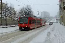 Auf den Strassenbahnschienen, die sich irgendwo unter dem Schnee verbergen, f�hrt der CJ-GTW ABe 2/6 634 am 27.11.2010 durch die Rue du Cr�t Richtung SBB-Bahnhof La Chaux-de-Fonds. 
