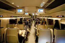 Pendolino-ETR610, Innenaufnahme im EC Richtung Milano. Enge Bestuhlung in der 2. Klasse. Fahrgastinfo �ber Bildschirme, wie im Flugzeug. Kurz vor dem Zwischenhalt wird man �ber Lautsprecher informiert. W�hrend Einfahrt in den Bahnhof Spiez, 28. Okt. 2010, 19:04