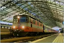  Swiss-Express  Re 4/4 11108 am Abend des 18. Dez. 2010 mit einem RE Gen�ve - Lausanne unter der Bahnhofshalle von Lausanne.

