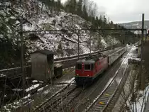 Re 4/4 II 11203 mit dreiteiligem NPZ als Regio 6540 bei Ausfahrt in G�nsbrunnen, 06.01.2011.