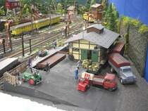 An der Gterhalle sind schon erste LKW's eingetroffen, sowie der Landmaschinenhndler der seinen Traktor verladen mchte.
Der entsprechende Waggon steht schon bereit. Whrend Staplerfahrer Klaus unter Beobachtung des LKW Fahrers Franz eine Kiste entldt.