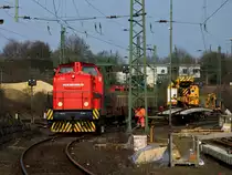 202 535-1  Chris  von SES zieht einen Bauzug am 25.03.2011 in Aachen West an einem 125to Kran der Firma Hering Gleisbau vorbei, der ein Gleisst�ck am Haken h�ngen hat.