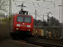 Sich elegant in die Kurve legend zieht 145 060-0 am 26.03.2011 auf der KBS 480 bei Aachen Rothe Erde einen langen Containerzug nach Aachen West.