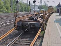 Der Rutschenwagen an einem Langschienenentladezug am 22.04.2011 in Aachen West. W�hrend der Zug langsam vorw�rts f�hrt, f�hrt der  Tintenfisch  mit zwei 120m langen Schienen an den Greifern genauso schnell ans Zugende und schiebt die Schienen �ber den Rutschenwagen vom Zug.