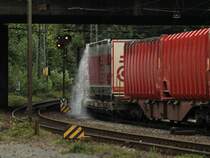 Wasserspiele am nachmittag des 24.07.2011 auf der Montzenroute. Cobra 186 214 (2822) zieht einen gemischten Klv-Zug aus Aachen West nach Belgien. In der ersten Rechtskurve am Fu der Rampe unter der Brcke Turmstrasse schiet das Wasser von den Planenaufliegern herunter. Der Zug stand scheinbar schon lnger in Aachen West, am vormittag hat es hier heftig geregnet. 