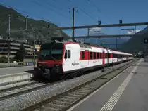 Regio 4149 bei Ausfahrt in Visp. Zurzeit sind die RegionAlps Dominios vierteilig, da infolge des Einbaus der automatischen Kupplungen (der Zug im Bild hat diese bereits) div. Einheiten in Z�rich abgestellt sind. Somit hat es zu wenig Z�ge, um zu den Hauptverkehrszeiten in Doppeltraktion zu fahren, desshalb wurden zus�tzliche Mittelwagen ins Wallis geholt. Im Bild ist es der  schwarze , normale Domino Wagen, 10.09.2011.