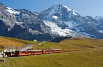 Jungfraubahn (JB) Triebwagen BDhe 4/8 - Nr. 211 und 214 fahren am 02.10.2011 von der Kleinen Scheidegg ninauf zum Eiger Gletscher, dann geht es in den �ber 7 km langen Tunnel durch Eiger und M�nch bis auf das Jungfraujoch.
Bild Mitte M�nch 4.107 m �.M., rechts das Jungfraujoch.
Auf einer L�nge von 9.34 Kilometern werden fast 1.400 H�henmeter �berwunden. Die Spurweite betr�gt 1.000 mm mit Zahnradsystem Strub , die H�chstgeschwindigkeit betr�gt 27 km/h (bergw�rts) und 14 km/h (talw�rts).
