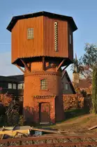 Lange ist her, dass Personenz�ge die Strecke der Westf�lischen Landeseisenbahn (WLE) benutzten, noch sehr viel l�nger ist her, dass Dampfloks diesen Wasserturm auf der Strecke zwischen Warstein und M�nster benutzten. So wurden dann auch alle abgerissen, dieser hier wurde gerettet, liebevoll restauriert und unter Denkmalschutz gestellt. Das Bahnhofsgeb�ude ist auch noch da, aber fast nicht mehr als solches zu erkennen.

Benutzt wird die Strecke aber immer noch, sogar in der letzten Zeit im zunehmenden Ma�e. Aur ihr werden die Steintransport zwischen den s�dwestf�lischen und m�nsterl�ndischen Stein- und Zementwerken aus Warstein, Erwitte und Beckum nach M�nster auf die Hauptstrecke transportiert.