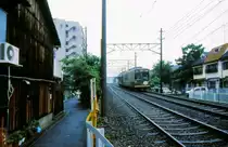 Ein Zweiwagenzug, gef�hrt vom noch gr�nen Wagen 613, mitten in der Stadt Kyoto bei Mibu, 11.Juli 1997. 