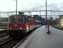 Die Re 4/4  11219 schiebt am 05.12.2011 einen soeben aus dem Tessin �berf�hrten TILO-Bt in die Luzerner Depot-Gleise. Das Sonnenlicht, das auf die rechte Lokseite reflektiert wird, kam �ber die EW III (rechts knapp zu erkennen).