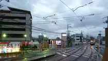 Ganz klein unter dem st�rmischen Himmel der sommerlichen Regenzeit kommt Wagen 105 gefahren. Kyoto-Tenjingawa, 16.Juni 2011. 