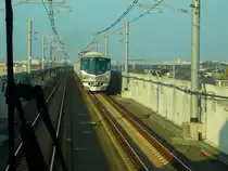 Grunddaten zum Tsukuba Express: 2005 er�ffnete Schnellverbindung (125 km/h) zwischen Tokyo und der Forschungs- und Wissenschaftsstadt Tsukuba (1970: ca.78'000, 2010: ca.215'000 Einwohner). 1067mm-Spur. L�nge 58,3 km, wovon die ersten 37,7 km mit Gleichstrom 1500V, die Fortsetzung mit Wechselstrom (20kV/50Hz) elektrifiziert sind. Im Bild kommt Zug TX-1113 (mit Endwagen TX-1613) (TX steht f�r  Tsukuba Express ) entgegen; bei Misato Ch��, 25.November 2009. (Aufnahme durch die get�nte und verglaste F�hrerstandr�ckwand)