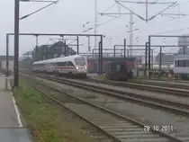 Bei tr�bem Wetter verl�sst ein d�nischer ICE-Triebwagen den d�nischen Grenzbahnhof Padborg und setzt seine Fahrt von Hamburg Richtung Aarhus fort. Daneben steht abgestellt der DSB-K�F-Rangiertraktor 285. 28.10.2011.
