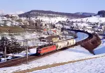 Vor dem Bau der L�rmschutzw�nde: Ae6/6 11416 rollt bei Zeihen den B�zberg hinab, 27.02.2004.