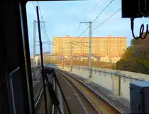 Tsukuba Express, Blick durch die verglaste F�hrerstandr�ckwand kurz vor dem Bahnhof Moriya, dem Ende der Gleichstromstrecke. In dieser noch sehr l�ndlichen Gegend werden um die neuen Bahnh�fe des Tsukuba Express herum riesige Siedlungen gebaut, sowohl mit Wohnbl�cken wie auch Einfamilienh�usern. Zumindest kriegen alle die Abendsonne (Bild). 25.November 2009. 