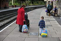 Bhf. Llangollen-Wales. Stolz zieht der Kleine seinen bunten Reisekoffer. Ob ihm der andere Koffer mit dem gr�sseren Thomas-Bild besser gef�llt ? Wenn ja, dann kann er ihn sicher noch tauschen. 12.8.2011