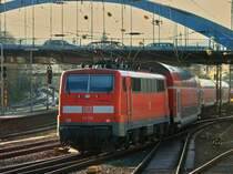 111 114 schiebt den RE4 am 29.11.2011 im Zickzack-Kurs unter der Burtscheider Br�cke aus Aachen Hbf. Links im Bild die S�drampe, die zum Buschtunnel und weiter nach Belgien f�hrt.