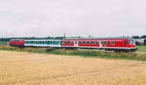 Am 15.5.01 schob die 218er Diesellok ihren Wendezug westlich von Burgbernheim noch durch Felder und Wiesen. Am linken Bildrand sieht man das Schild f�r Strecken-km 3, das zum Vergleich mit der folgenden Aufnahme dient.