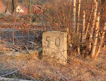 Ein stummer Zeitzeuge. Dieser Kilometerstein ist einer der wenigen, die von der Strecke Kassel-Eschwege, der sog. Kanonenbahn, �brig geblieben ist. Im Mai 1985 fuhr hier der letzte Zug. Mit dem Bau der A44 bei Walburg wurden dann die ersten Streckenabschnitte abgerissen. In Eschwege West ebenso bei Beginn der Bauarbeiten des Eschweger Stadtbahnhofs im Jahre 2008. Seit Juli 2010 kann auf einem gut 2 km langem Teilst�ck bei Waldkappel/Bischhausen Draisine fahren. Zum Hessentag 2006 in Hessisch-Lichtenau wurde das St�ck von Kassel nach HeLi zur Tram-Linie wieder um- und ausgebaut. Die alte Kilometrierung gilt heute wieder f�r die Cantus-Z�ge die hier am B� Eltmannshausen/Oberhone die Hauptstrecke verlassen und auf den Spuren der alten Kanonenbahn bis zum Stadtbahnhof Eschwege fahren. Aufgenommen am 18.01.2012.