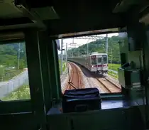 T�bu-Konzern Serie 1xxxx: Weit draussen auf dem Land im Nordwesten von Tokyo legt sich ein entgegenkommender Zug in die Kurve, gef�hrt von der 4-Wageneinheit 11454 (nordseitiger Endwagen 14454). Bei Musashi Ranzan, 24.Juni 2011.　(Aufnahme durch die verglaste F�hrerstandr�ckwand)