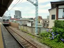 T�bu-Konzern Serie 1xxxx - Einfahrt nach Tokyo: Der 10-Wagenzug 11003 in Naka Itabashi, 24.Juni 2011. Auf der Tafel in der Bildmitte steht:  Verkauf von neu anzulegenden Gr�bern - eine Parzelle f�r ewige Nutzung kostet ab (ca.) 12000 Euro. Fukusenji-Tempel, religi�se K�rperschaft, Schule des S�t�-Zen-Buddhismus. 