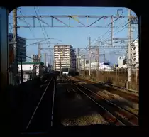 Serie 811 - Begegnungen: Bei der Ausfahrt aus Hakata begegnet ein Regionalzug Serie 811, während ein Shinkansen-Hochgeschwindigkeitszug Richtung Tokyo (das er in 5 1/4 Std. erreichen wird) davonfährt. 1.Dezember 2010. (Aufnahme durch die verglaste Führerstandrückwand eines Gegenzugs) KAGOSHIMA HAUPTLINIE (NORD)