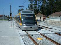 MP 063, Linie B (rot) Povoa de Varzim - Estadio do Dragao, f�hrt am 11.05.2006 in die Station Modivas Centro ein. Die 80 km/h sind die H�chstgeschwindigkeit au�erhalb von Porto.