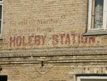 Holeby - Bahnhof an der alten stillgelegten Strecke Nyk�bing - R�dby Havn. Vor Jahren waren noch das Stationsschild und die Hinweise auf die Entferungen zu den Nachbarstationen sichtbar
(1 skand. Meile = 10 km)