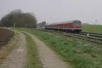 218 472-9 schiebt ihren RE von Kempten nach M�nchen, im Hintergrund ist die Pfarrkirche St. Johannes Baptist in Kaufering zu sehen, bei Epfenhausen, 14.04.12
