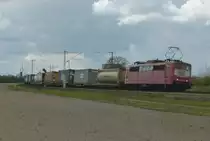 Die orientrote 151 134-4 ist mit einem Containerzug am 18.04.2012 bei Wagh�usel